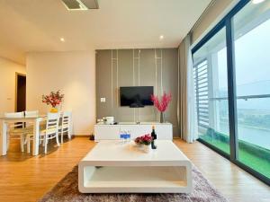 sala de estar con mesa blanca y TV en Greenbay Premium homestay Hạ Long Bay en Ha Long