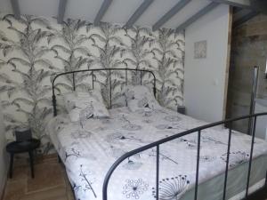 a bedroom with a bed with a black and white bedspread at Gîtes les Bernes in Saint-Pardon-de-Conques