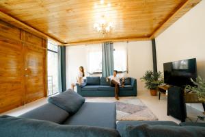 two people sitting on a couch in a living room at CASA AGUELO Chocolate Hills in Carmen