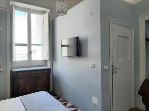 una camera con letto e TV a parete di Dimora " Le Rose " a Lecce
