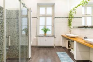 uma casa de banho com uma cabina de duche em vidro e um lavatório. em Großzügige 185m2-Altbauwohnung in Bestlage 7Zimmer-2Bäder-2Küchen-2WCs em Hamburgo