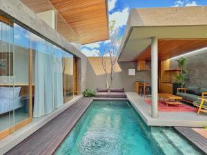 einen Pool in einem Haus mit einem Wohnzimmer in der Unterkunft Domisili Villas Canggu Bali by Fays Hospitality in Canggu