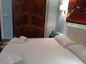 un letto bianco con due asciugamani sopra di Dimora " Le Rose " a Lecce