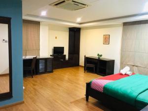 Habitación con cama, escritorio y TV. en Maxwell inn en Taiping