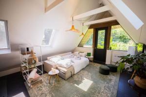 a bedroom with a white bed and some windows at Wonderful 50m2 Loft Eindhoven - KS8 in Eindhoven