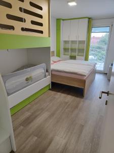 a bedroom with two beds and a large window at Family apartment Moravske Toplice in Moravske Toplice
