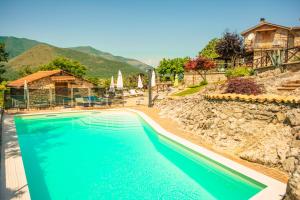 a swimming pool in front of a house at Villa La Voce Del Vento in Pastena