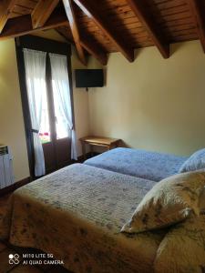 a bedroom with a bed and a window at Casa A Ruata in Torla-Ordesa