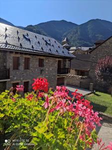 a garden with red flowers in front of a building at Casa A Ruata in Torla-Ordesa