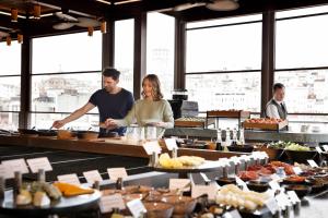 a man and a woman standing at a buffet at JW Marriott Istanbul Bosphorus in Istanbul