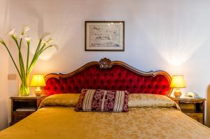 1 cama con cabecero rojo y almohada en Hotel Ariel Silva, en Venecia