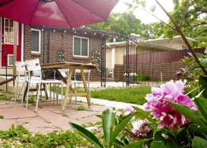 丹佛的住宿－Family-Friendly Mid-century Modern Retreat，庭院配有桌椅和遮阳伞。