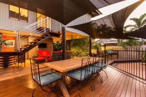 a wooden table and chairs on a deck at Asrama Broome in Broome