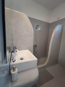 a bathroom with a white sink and a shower at Agnanti Hotel in Adamantas