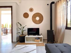 un salon avec une télévision et un canapé dans l'établissement PRIMAVERA, à Kalamaki