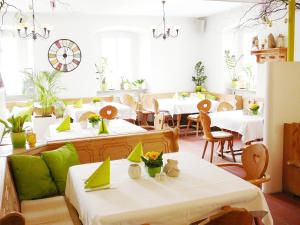 un restaurante con mesas blancas y sillas con toques verdes en Apartments Erbgericht, en Bad Schandau