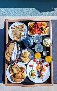 ein Tablett mit Speisen verschiedener Art zum Frühstück in der Unterkunft Sunset Hill Suites in Mykonos Stadt