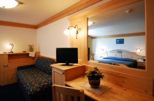 圣马蒂诺-迪卡斯特罗扎Hotel Cristallo的带沙发、电视和床的客厅