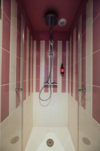 bagno con doccia a strisce rosa e bianche di JOST Hotel Montpellier Centre St Roch a Montpellier