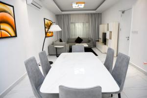 a living room with a white table and chairs at White Stone Apartments Nyarutarama in Kigali