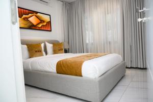 a bedroom with a large bed in a room at White Stone Apartments Nyarutarama in Kigali