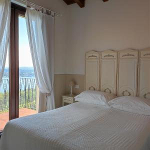 um quarto com uma cama e uma grande janela em Agriturismo Il Casale Del Lago em Gardone Riviera