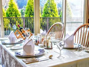 a table with plates and wine glasses on a balcony at glampark Monte Rosa Hyogo in Kamikawa
