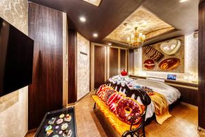 a bedroom with a bed and a couch with donuts on it at SWEETS HOTEL KYOTO -Adult Only in Yawata