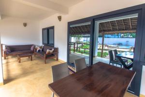 una sala da pranzo con tavolo e sedie in legno di Pingwe Beach Apartments a Pingwe
