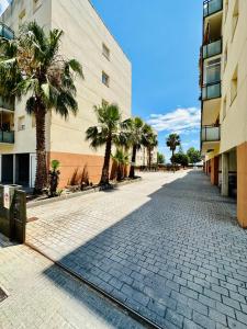 a cobblestone street with palm trees in front of a building at BOOK VILA-SECA TOWN in Vilaseca de Solcina