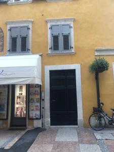 un edificio amarillo con una puerta y ventanas negras en MUROS - Design Apartments in Trento en Trento