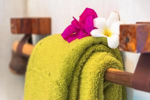un asciugamano verde con un fiore sopra di Pingwe Beach Apartments a Pingwe