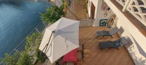 an overhead view of a patio with two chairs and an umbrella at Kuća Ugor in Lun +77 photos