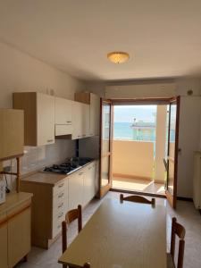a kitchen with a table and a view of the ocean at Duca degli Abruzzi in Caorle
