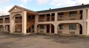 an empty parking lot in front of a building at American Inn in Corsicana