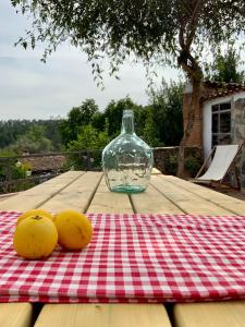 two oranges sitting on a picnic table with a bottle at La Casita in Fuente del Oro