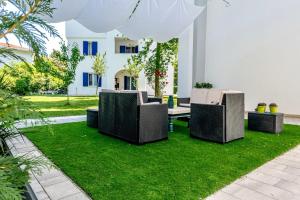 un patio con sedie e prato in un cortile di DunaBlu a Duna Verde