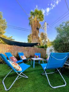 a group of chairs and a table and a hammock at The Lowest Place on Earth B&B in Neʼot HaKikar