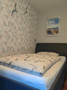 1 dormitorio con 1 cama con pared geométrica en Gästehaus Arkona en Tönning