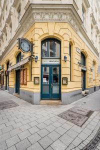 a yellow building with a clock on the front of it at Pyvo Street Home with balcony near the Danube in Budapest