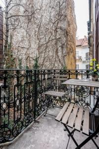 une clôture en fer forgé avec deux tables et un banc dans l'établissement BpR Pyvo Street Home with balcony, à Budapest