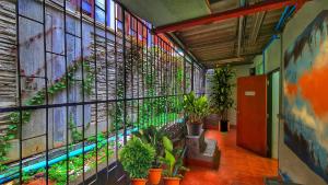 um corredor com plantas na parede de um edifício em Aloft Hotel and Hostel Pattaya em Nong Prue
