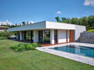 una casa con piscina frente a ella en ApartmentsGarda - Villa Bardolino, en Garda
