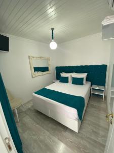 1 dormitorio con 1 cama grande con almohadas azules y blancas en Otantik Shumen, en Shumen