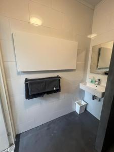 ein Bad mit einem Waschbecken und einem Handtuch an der Wand in der Unterkunft B&B Sloterpark in Amsterdam