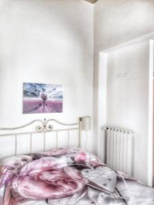 um quarto com uma cama com um edredão rosa em I FIORI self-check-in em Capanne