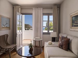 a living room with a couch and a window at The Petra in Patmos