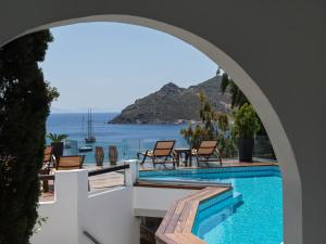 an archway over a swimming pool with a view of the ocean at The Petra in Patmos