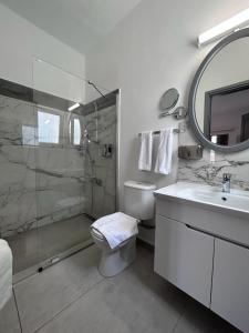 een badkamer met een douche, een toilet en een wastafel bij Royal Goddess Guest House, Walled City in Famagusta