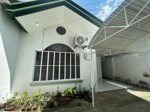 een wit gebouw met een ventilator en een aantal planten bij Lanang Bungalow by The Townes in Davao City